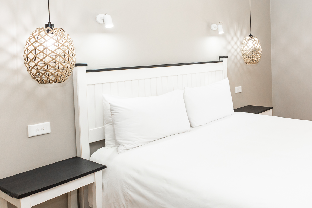 En-suite bedroom with queen bed and pendant lights