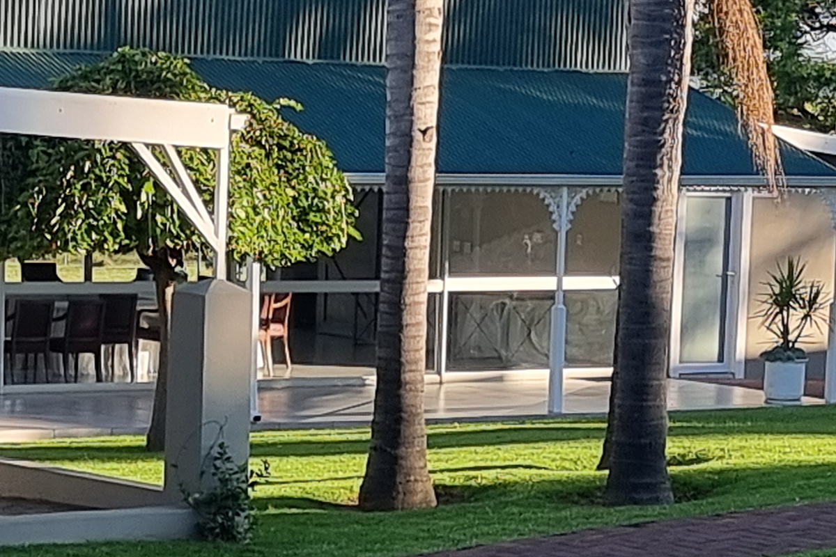 Palms and lawns beside the glass enclosed veranda