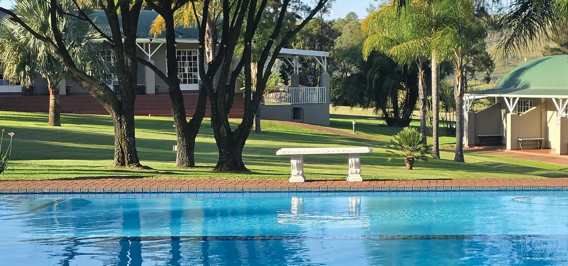 Swimming pool, lawns and lodge buildings at Newcastle Country Lodge
